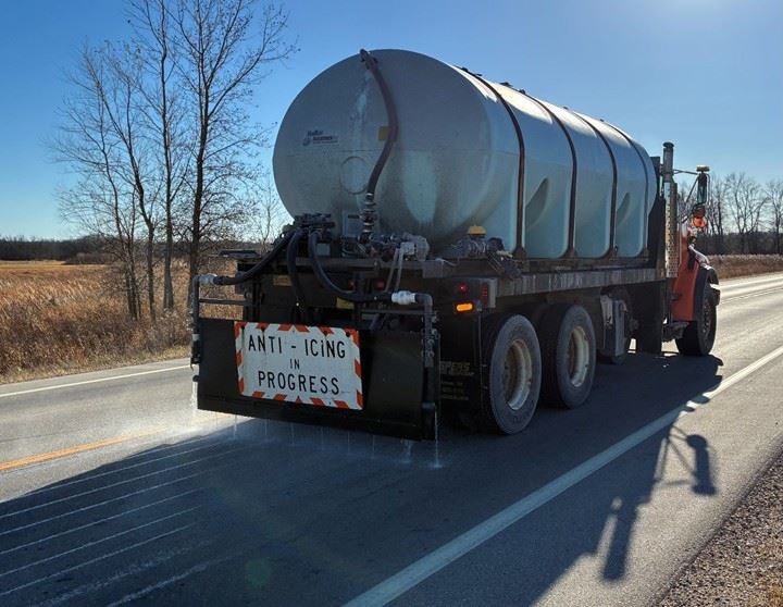 Large truck with anti-icing equipment treating the roadway with salt brine.