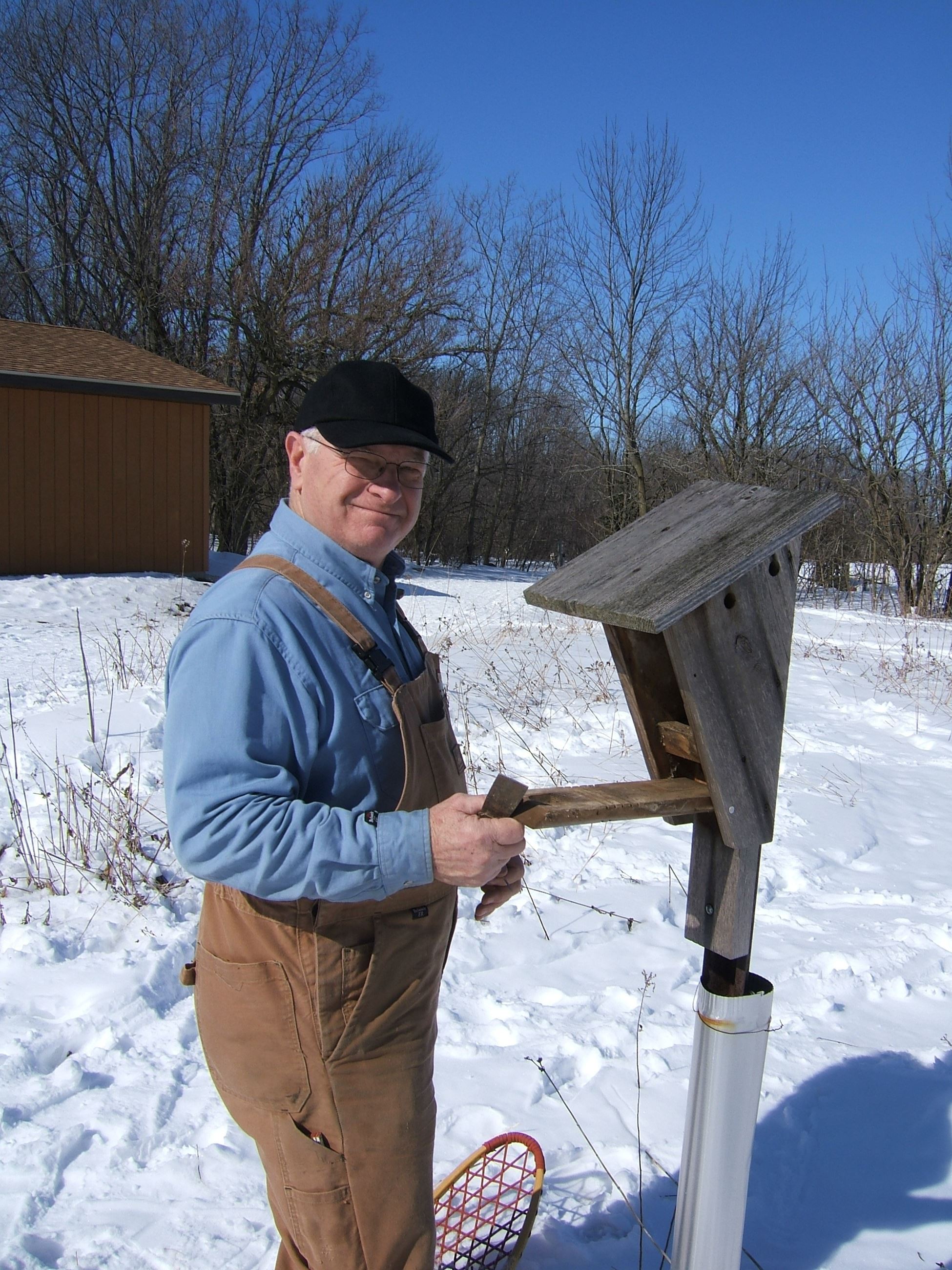 a picture of a man next to a bluebird house